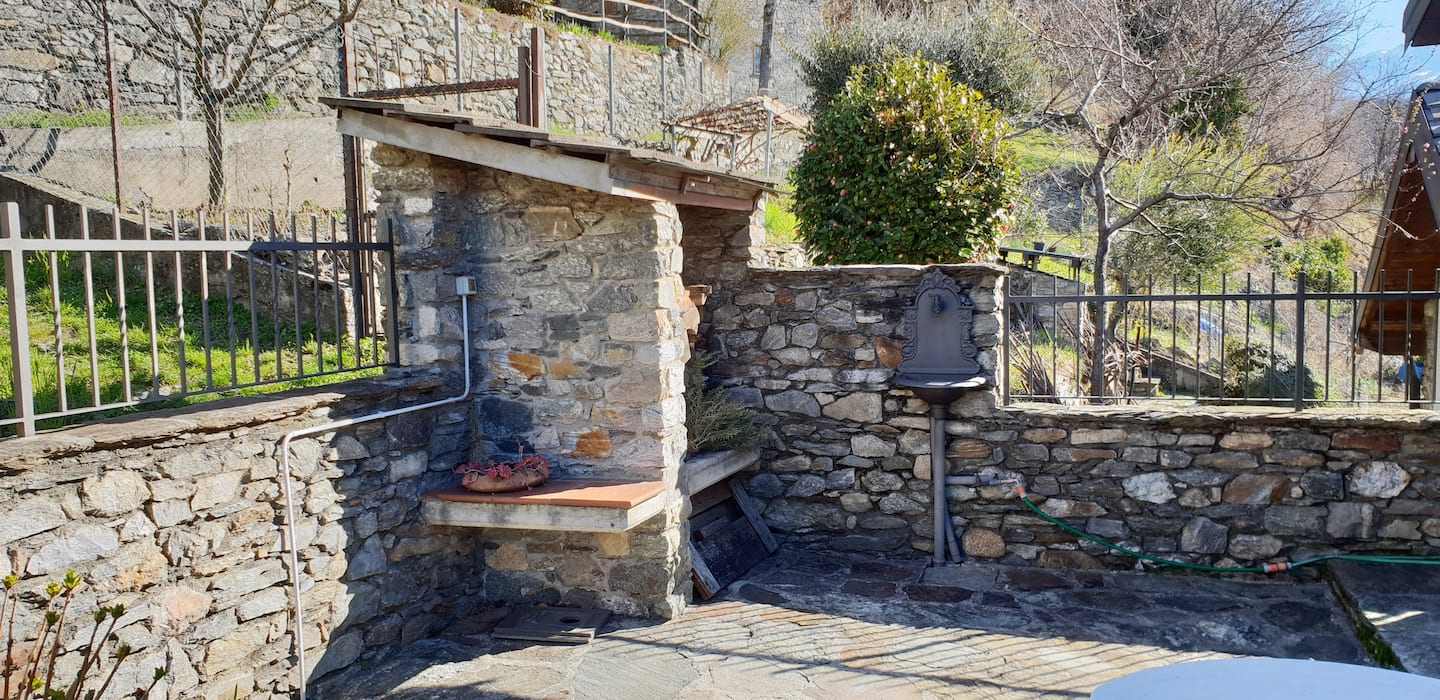 Grillplass murt i naturstein, med benk og bord