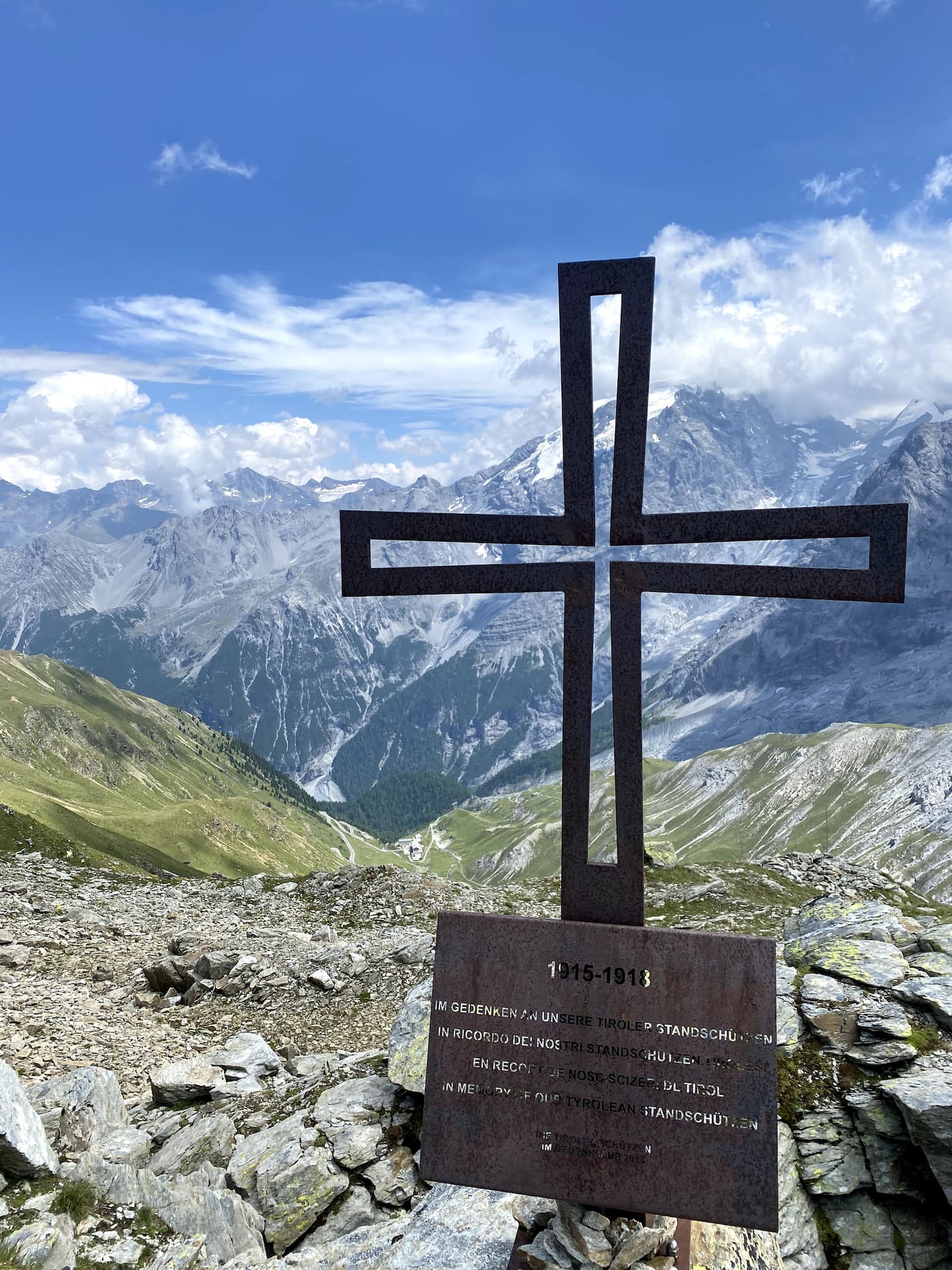 Toppkors av jern med alpetopper i bakgrunnen