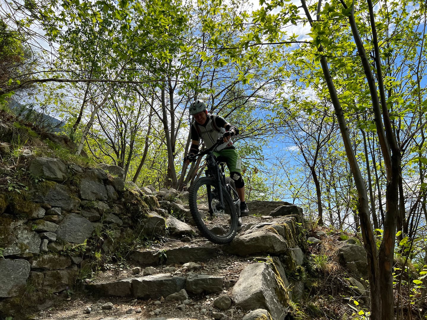 Terrengsyklist på en steinsti i skogen